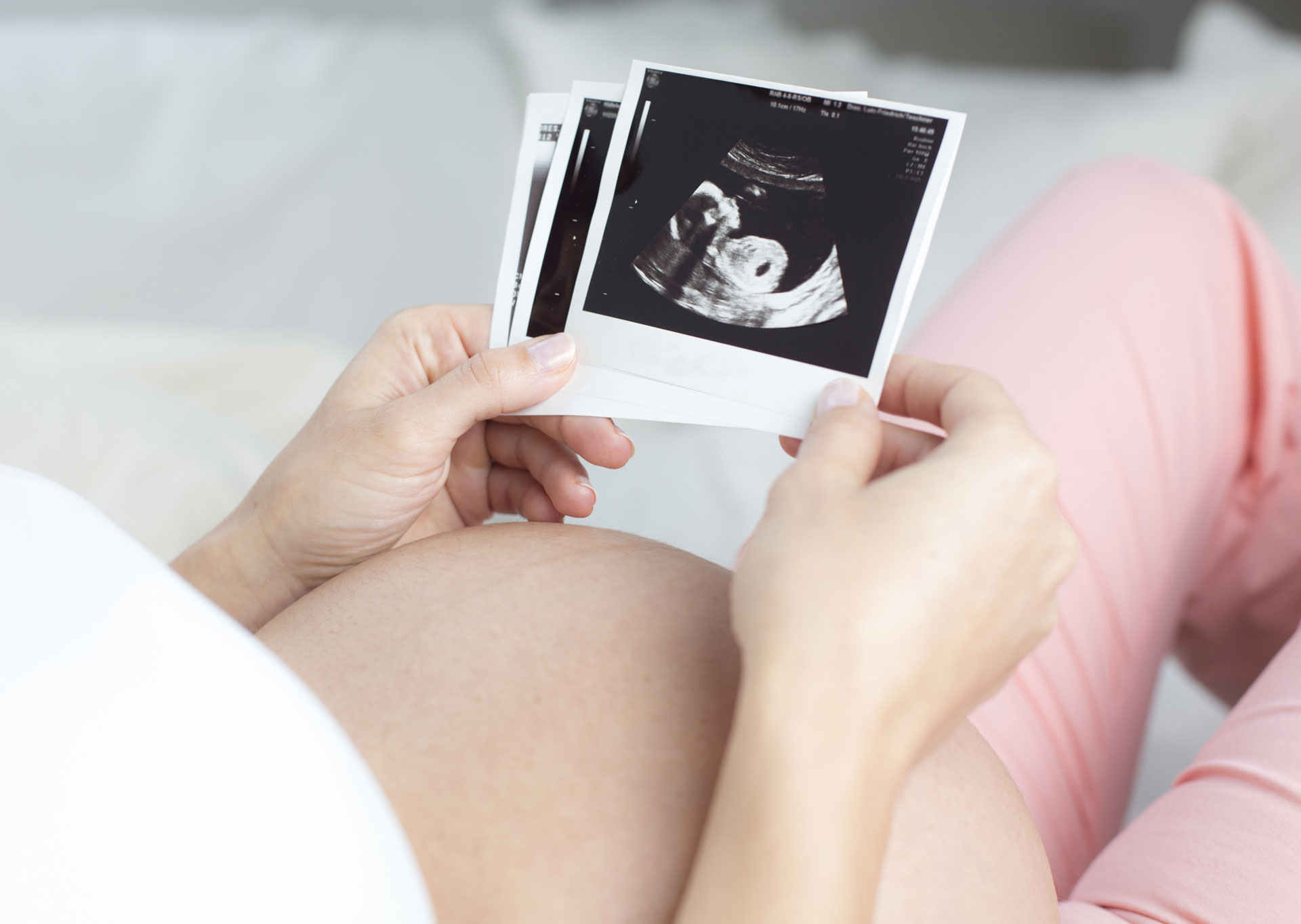 Schwangere Frau schaut sich ein Ultraschallbild an